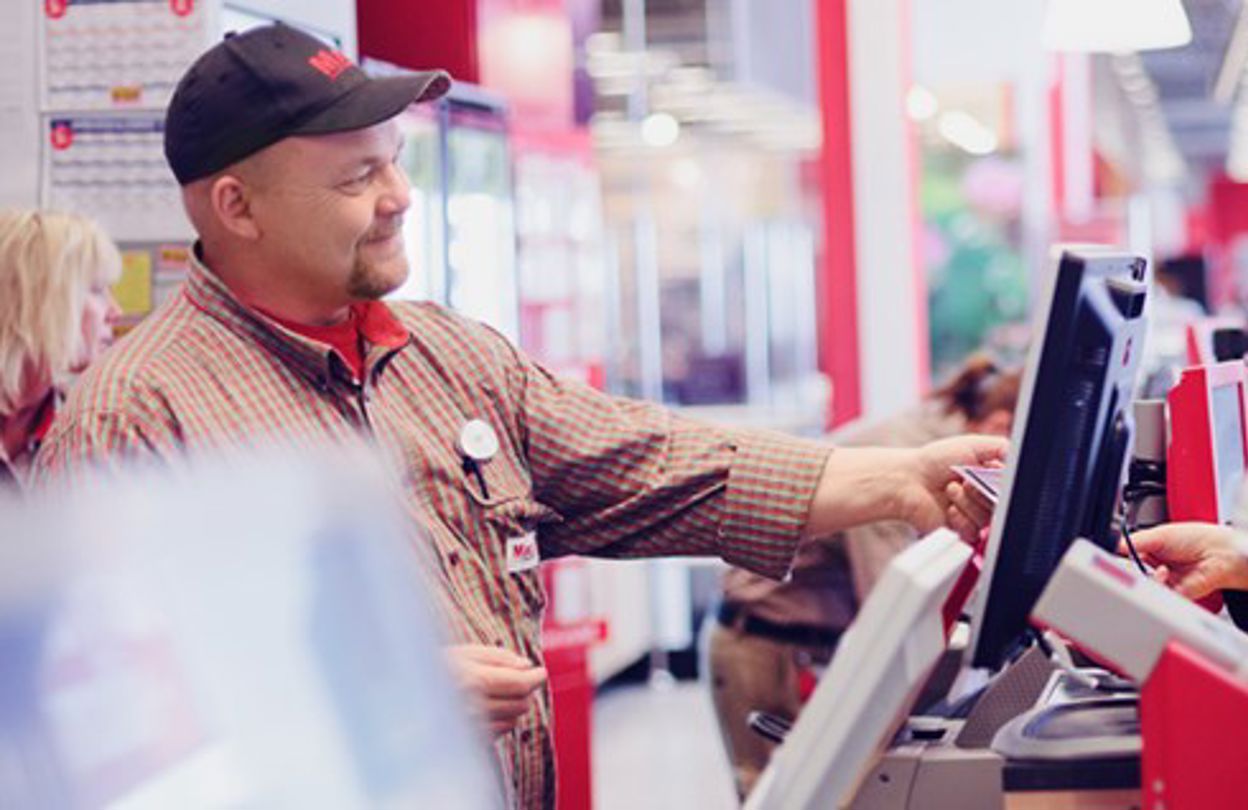 Butikspersonal expedierar kund i en förbutik