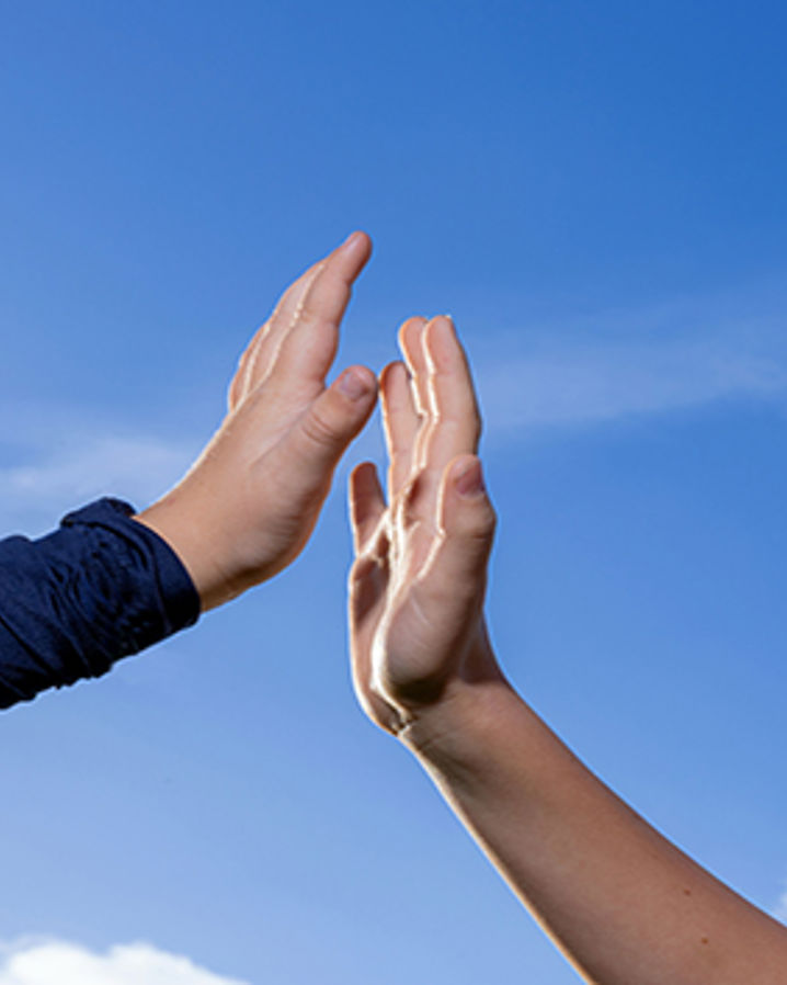 Tvp händer uppe i luften som gör high five