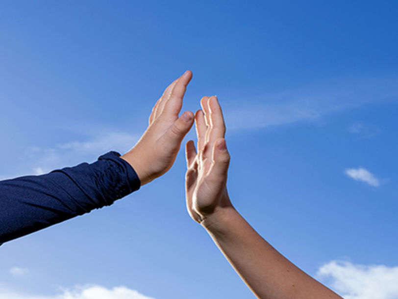 Tvp händer uppe i luften som gör high five