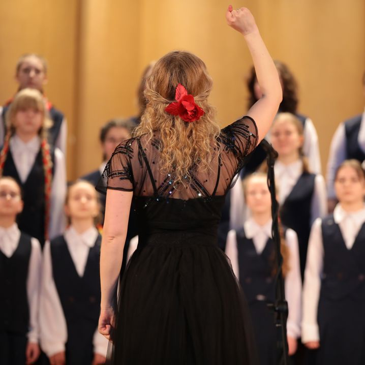 Körledare står framför sin kör och dirigerar