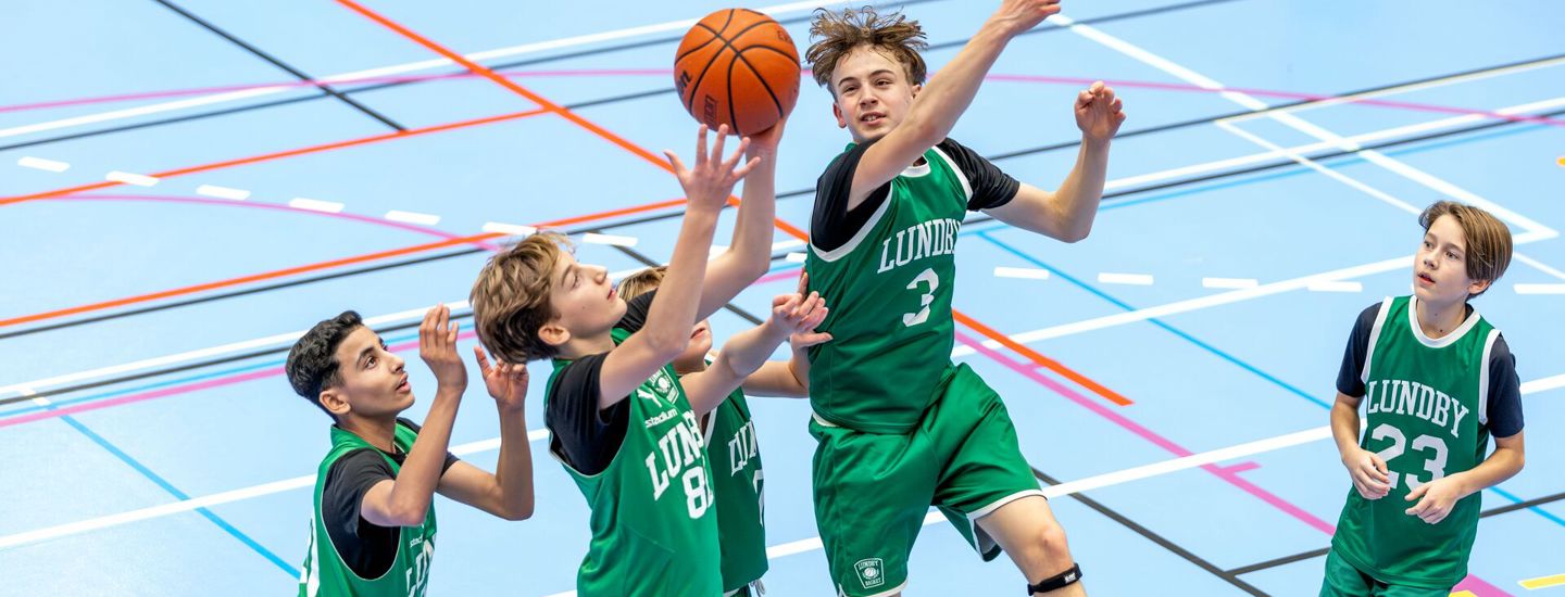Pojkar spelar basket och kämpar om bollen