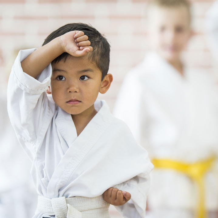 En ung pojke i kampsportskläder tränar kampsport