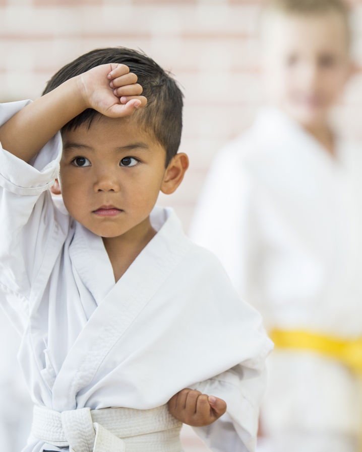 En ung pojke i kampsportskläder tränar kampsport