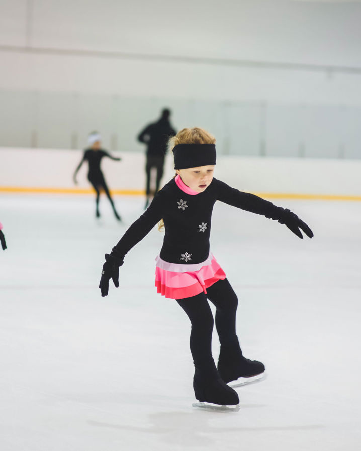 Flickor åker konståkning i en ishall