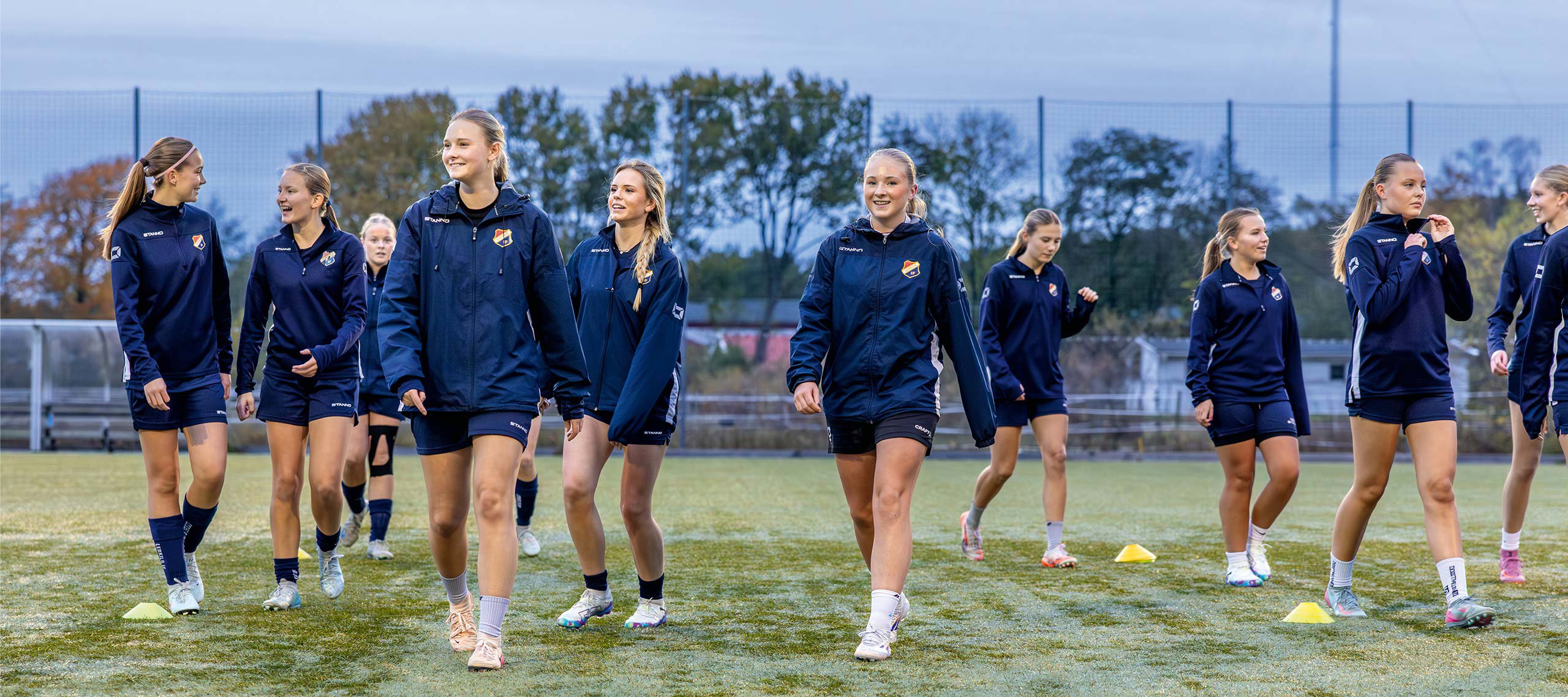 Flickor i fotbollslag har träning på plan