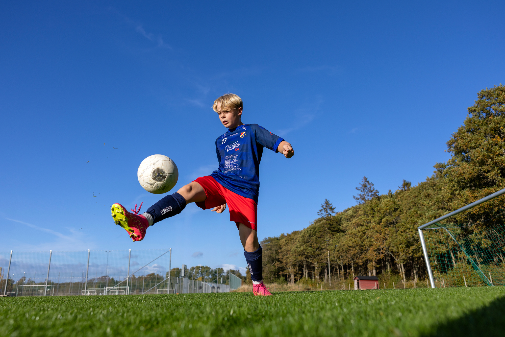 Lerkil fotbollsspelare bollar med fotbollen