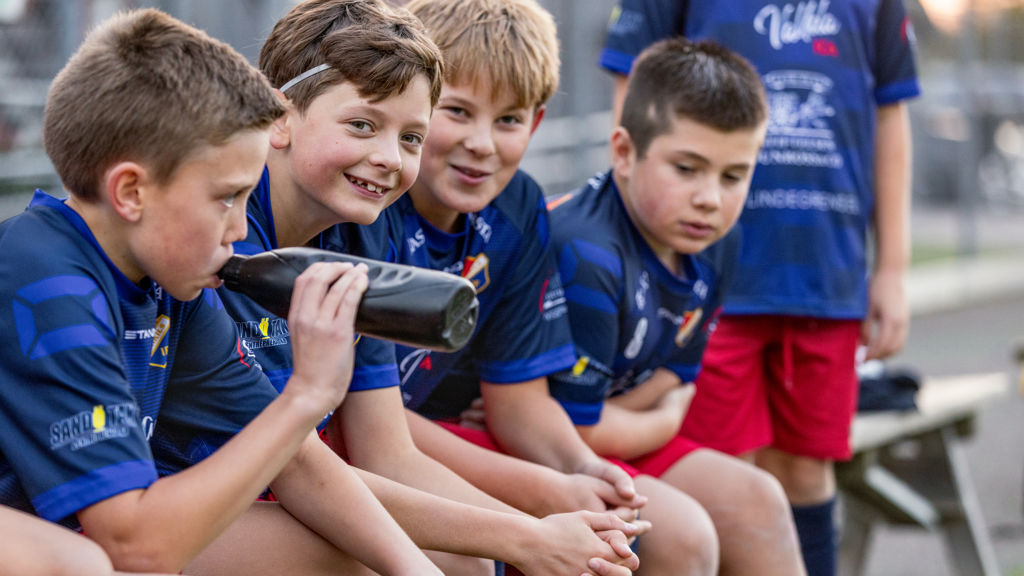 Lerkil pojkar sitter på bänken och umgås