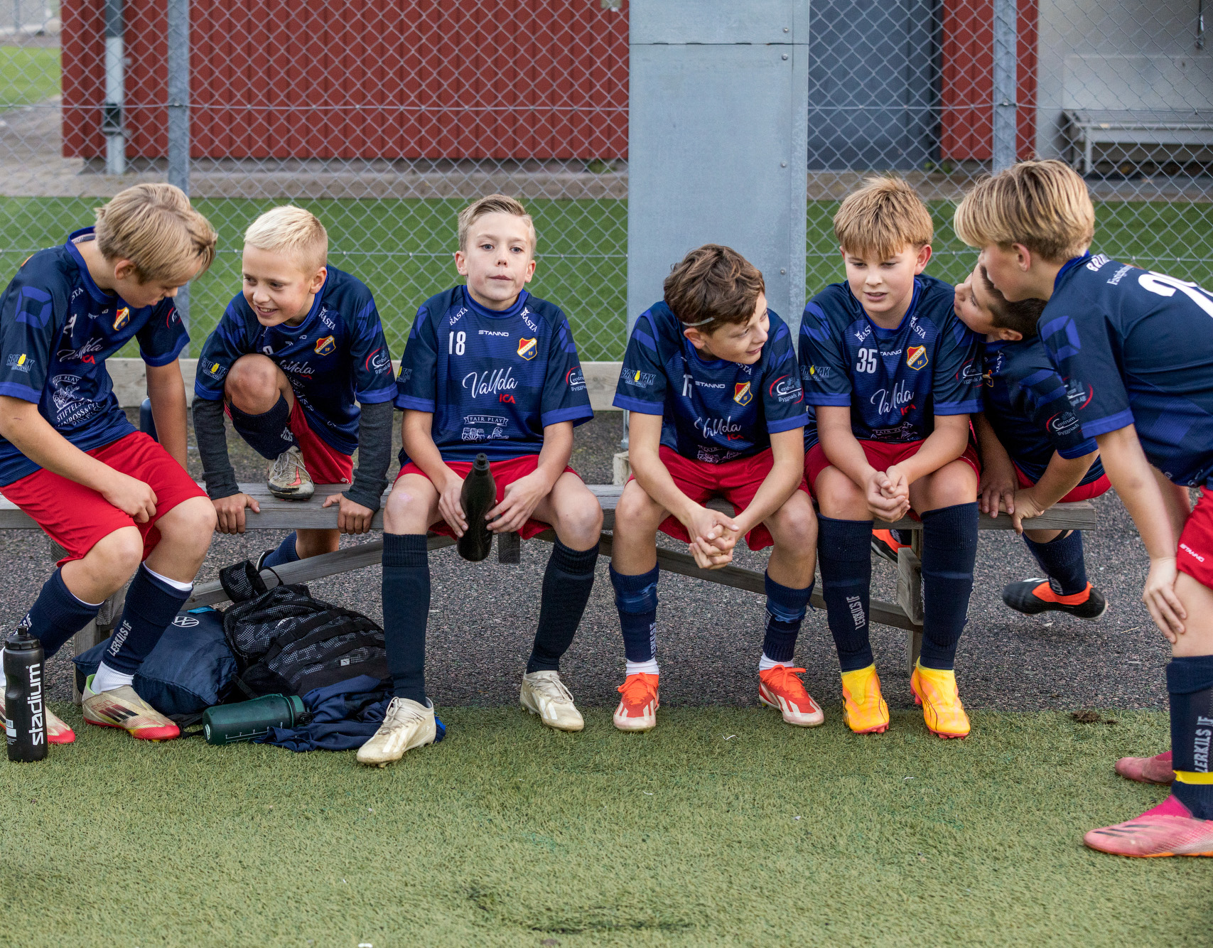 Lerkil pojkar sitter på bänken, skrattar och converserar i sann laganda