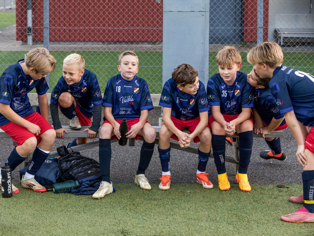 Lerkil pojkar sitter på bänken, skrattar och converserar i sann laganda