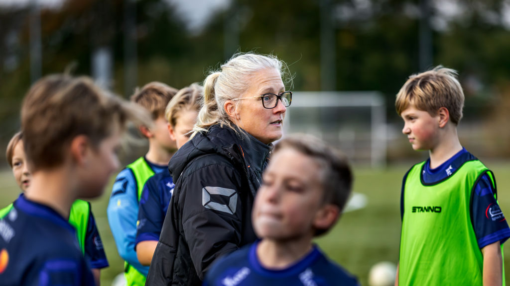 Lerkil pojkars fotbollstränare Josefina på planen pratar med pojkarna