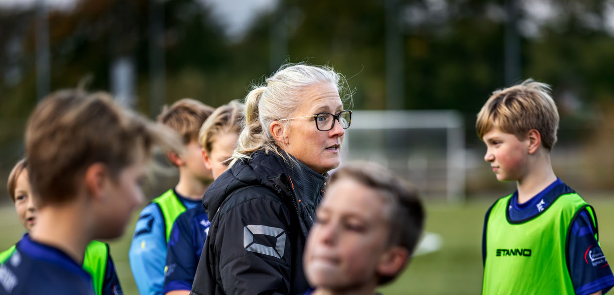 Lerkil pojkars fotbollstränare Josefina på planen pratar med pojkarna