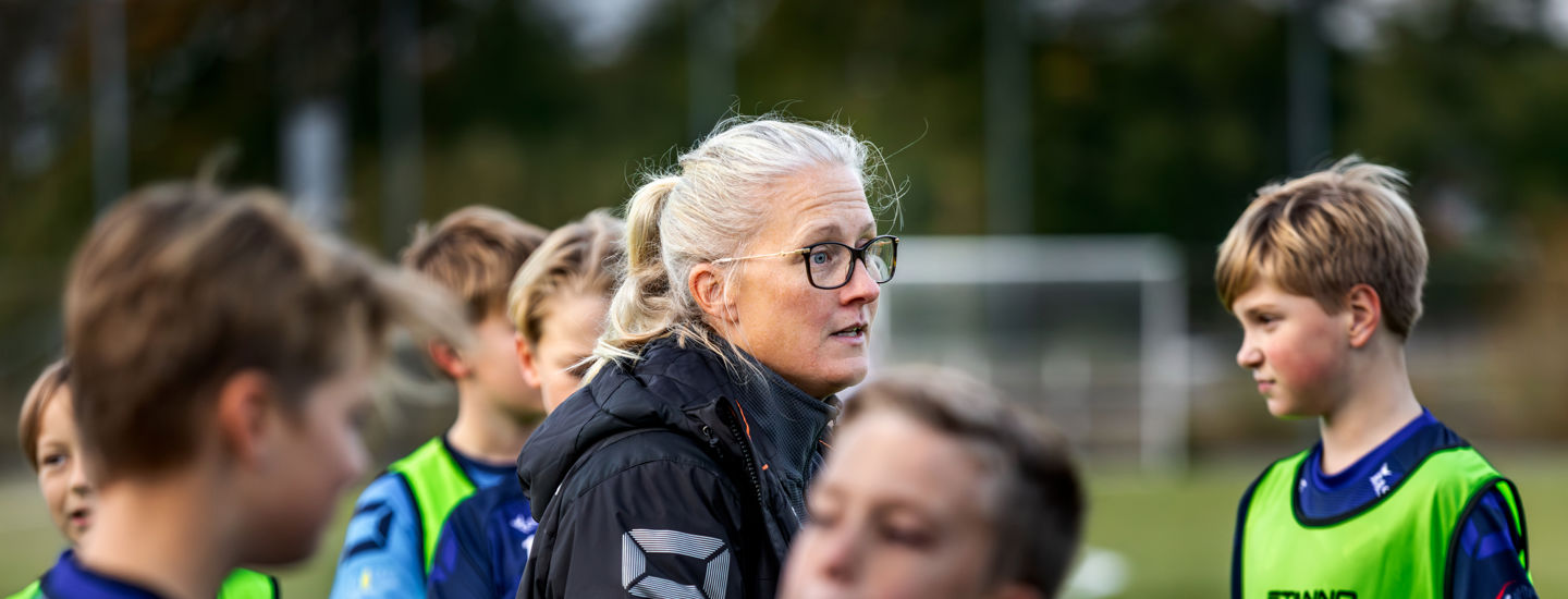Lerkil pojkars fotbollstränare Josefina på planen pratar med pojkarna