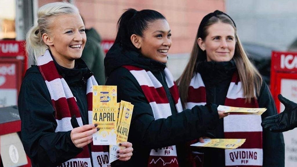 Glada tjejer med rödvit-randiga halsdukar ler och säljer bingolotter till påsk