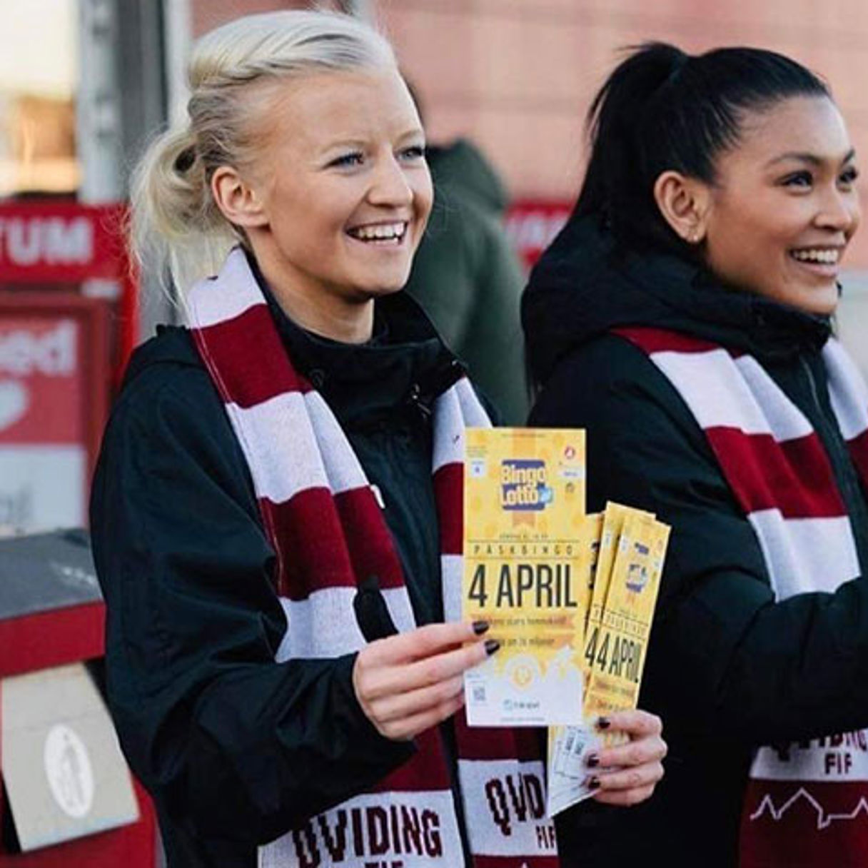 Glada tjejer med rödvit-randiga halsdukar ler och säljer bingolotter till påsk