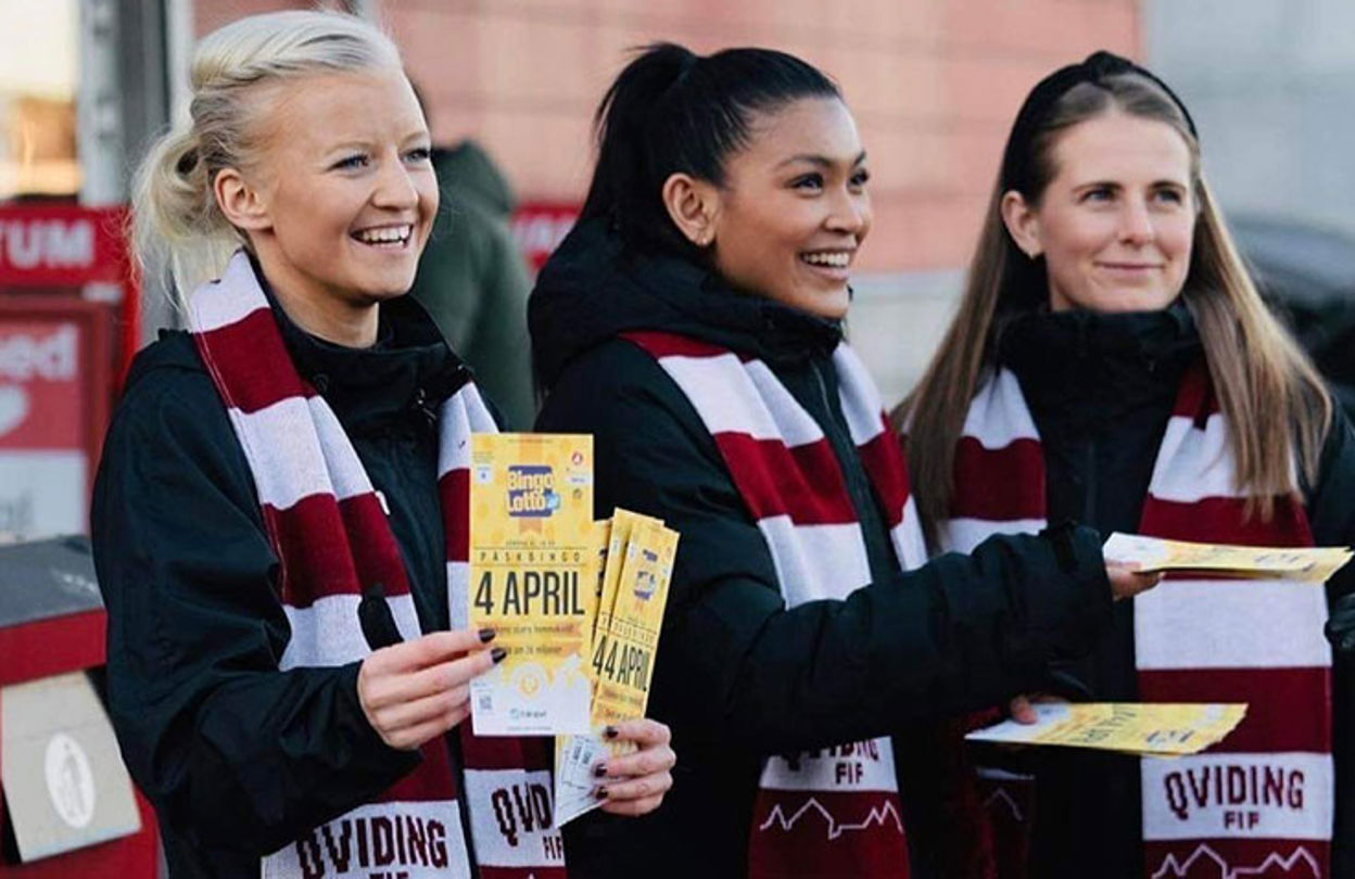 Glada tjejer med rödvit-randiga halsdukar ler och säljer bingolotter till påsk