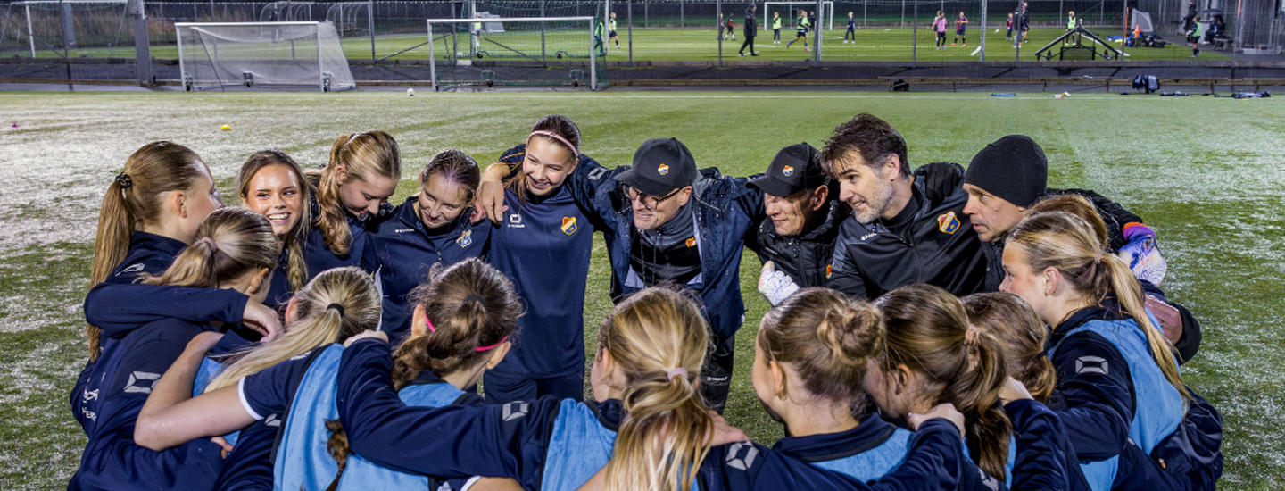 Ett flickfotbollslag har samlats i klunga för att snacka ihop sig