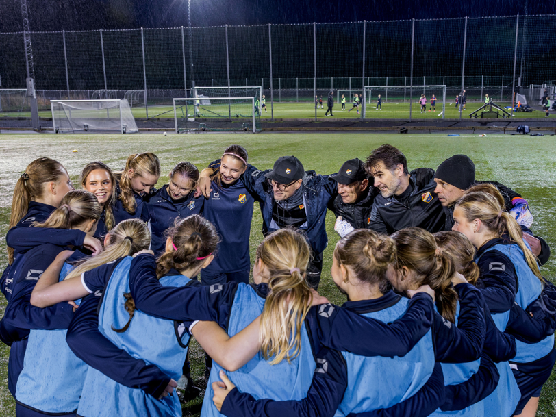 Ett flickfotbollslag har samlats i klunga för att snacka ihop sig
