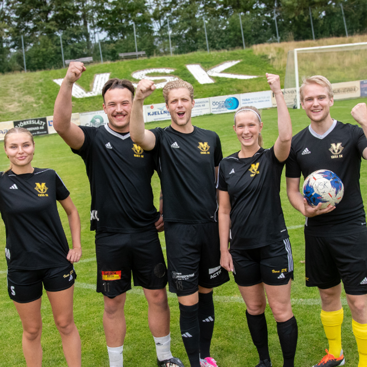 Jublande killar och tjejer från Vara SK lyfter armen i segergest på fotbollsplan