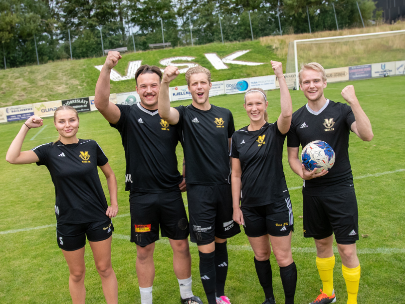 Jublande killar och tjejer från Vara SK lyfter armen i segergest på fotbollsplan