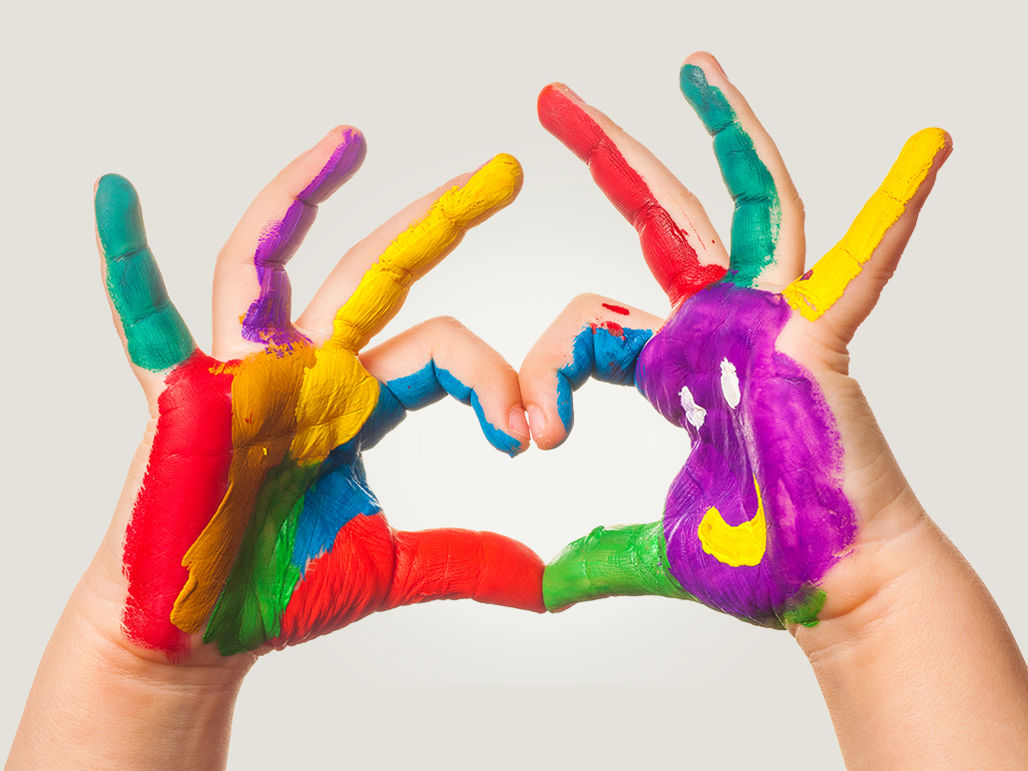 Barnhänder som formar ett hjärta målad i färgglada färger
