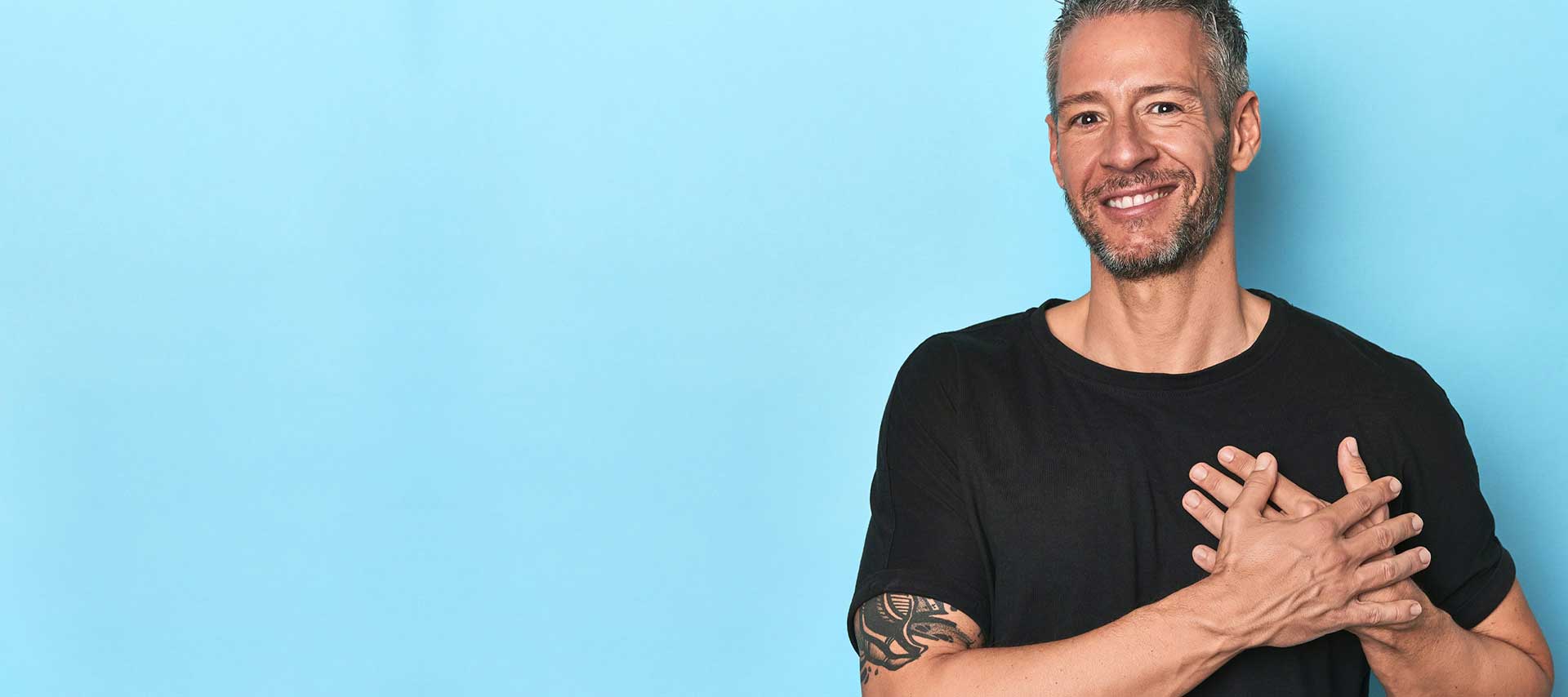 En man som tar sig över hjärtat