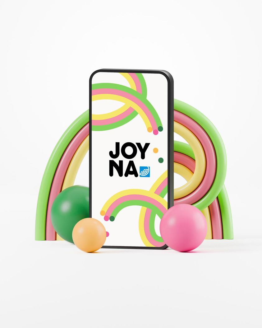 Logotypen för JOYNA i en mobiltelefon omgiven av färgglada bollar