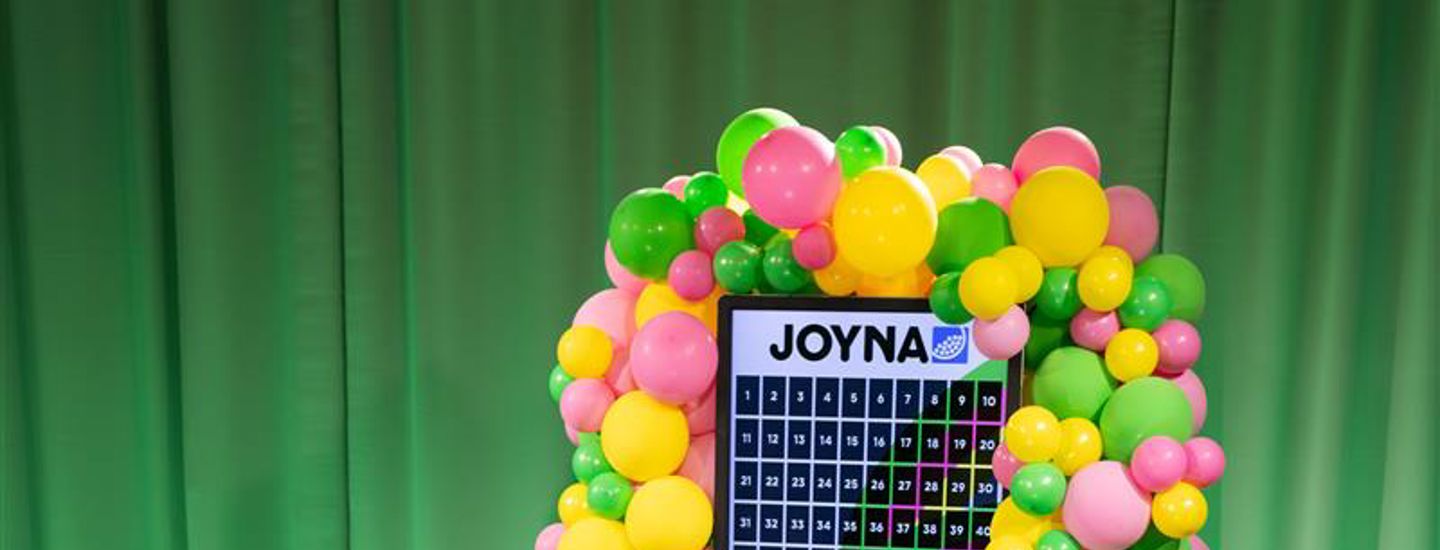 En skärm med JOYNA lotter med ballonger runt skärmen