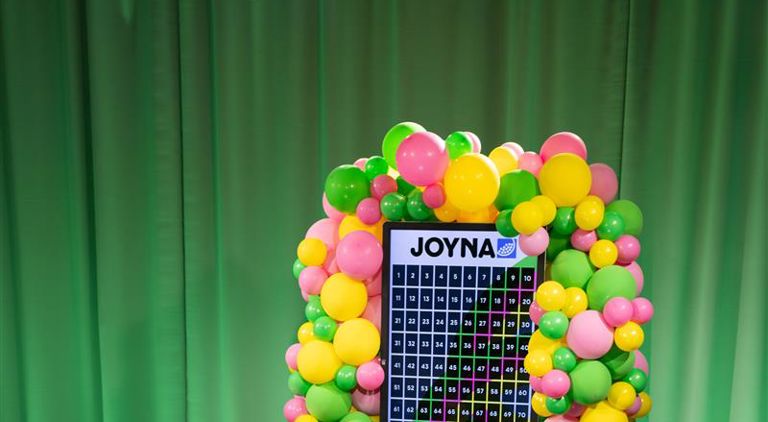 En skärm med JOYNA lotter med ballonger runt skärmen