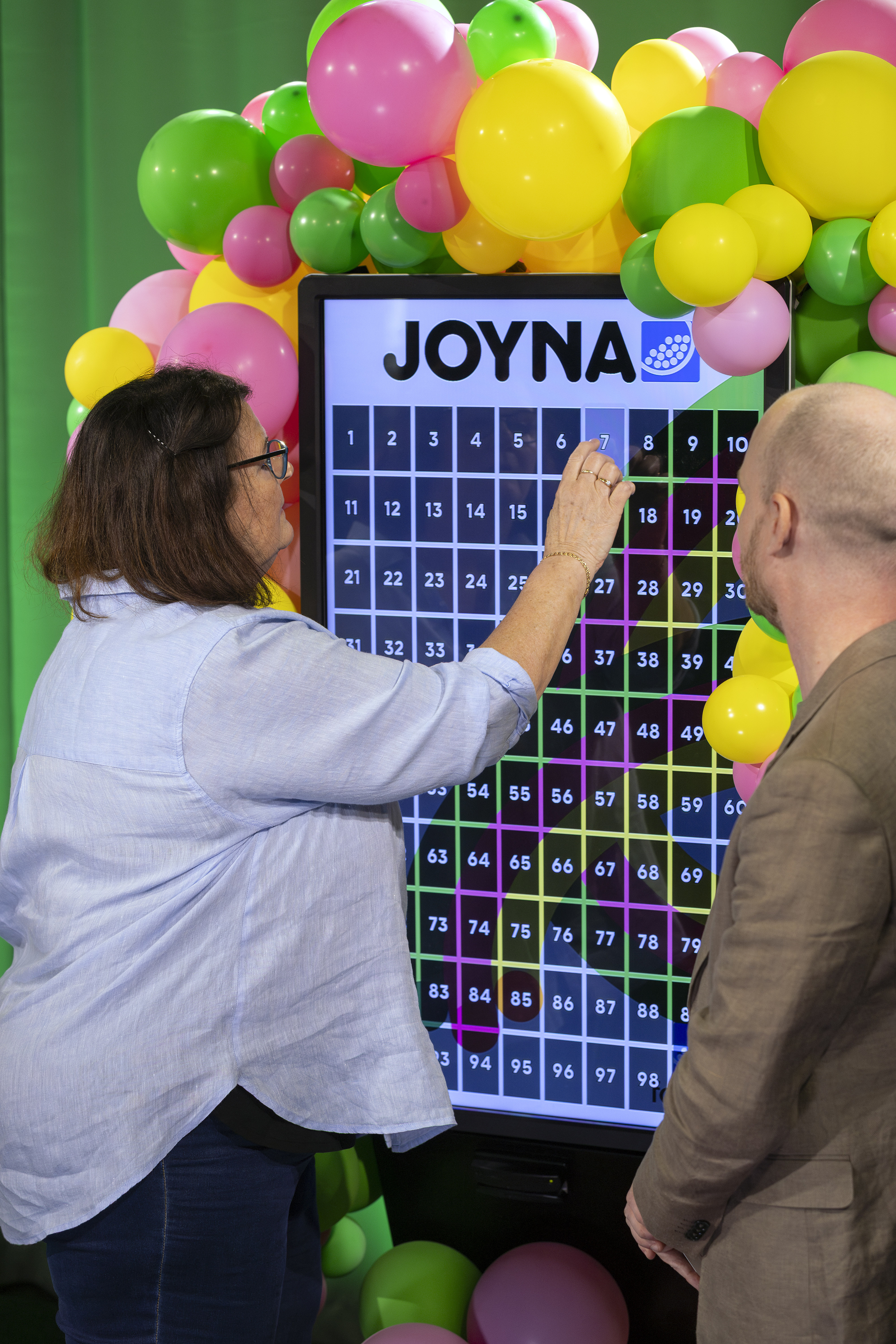 En kvinna som väljer lott nummer 7 i JOYNA dragning
