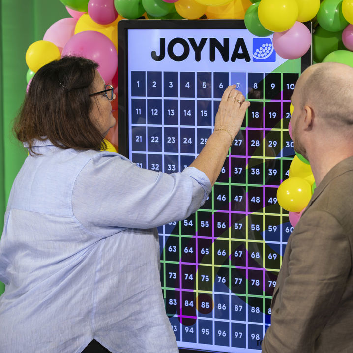 En kvinna som väljer lott nummer 7 i JOYNA dragning