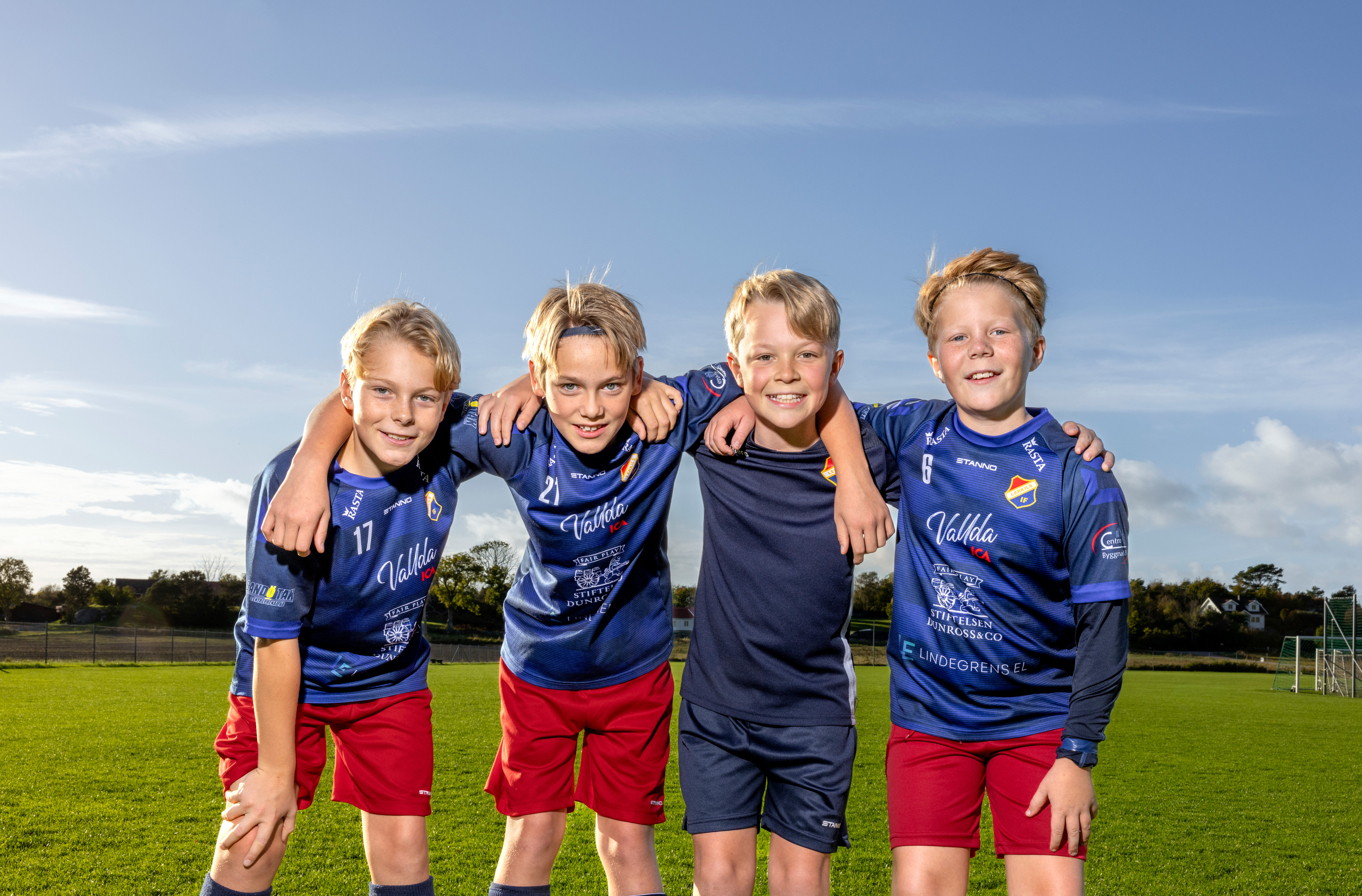 Glada pojkar på en fotbollsplan som håller om varandra