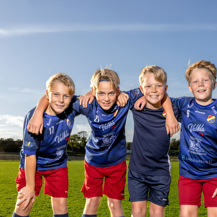 Glada pojkar på en fotbollsplan som håller om varandra