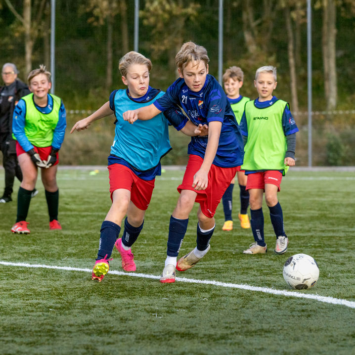 Pojkar som spelar fotboll på plan