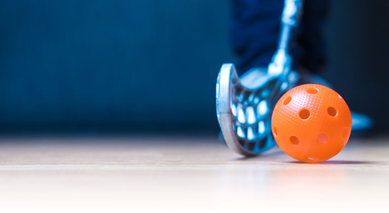 Bladet på en grå innebandyklubba och en orange innebandyboll