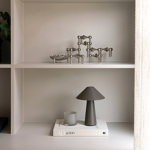 Lampa och ljuslykta stående på beige bok