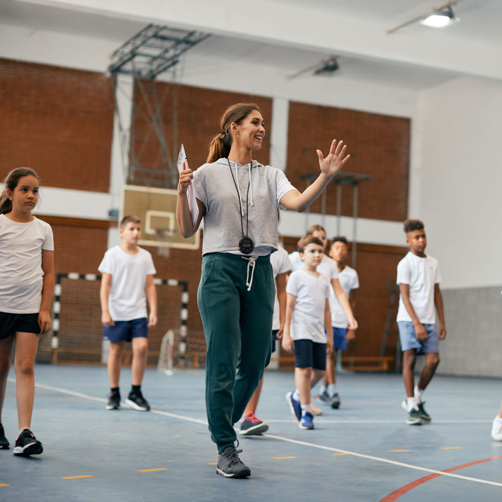 Barn i en gympasal med en idrottslärare