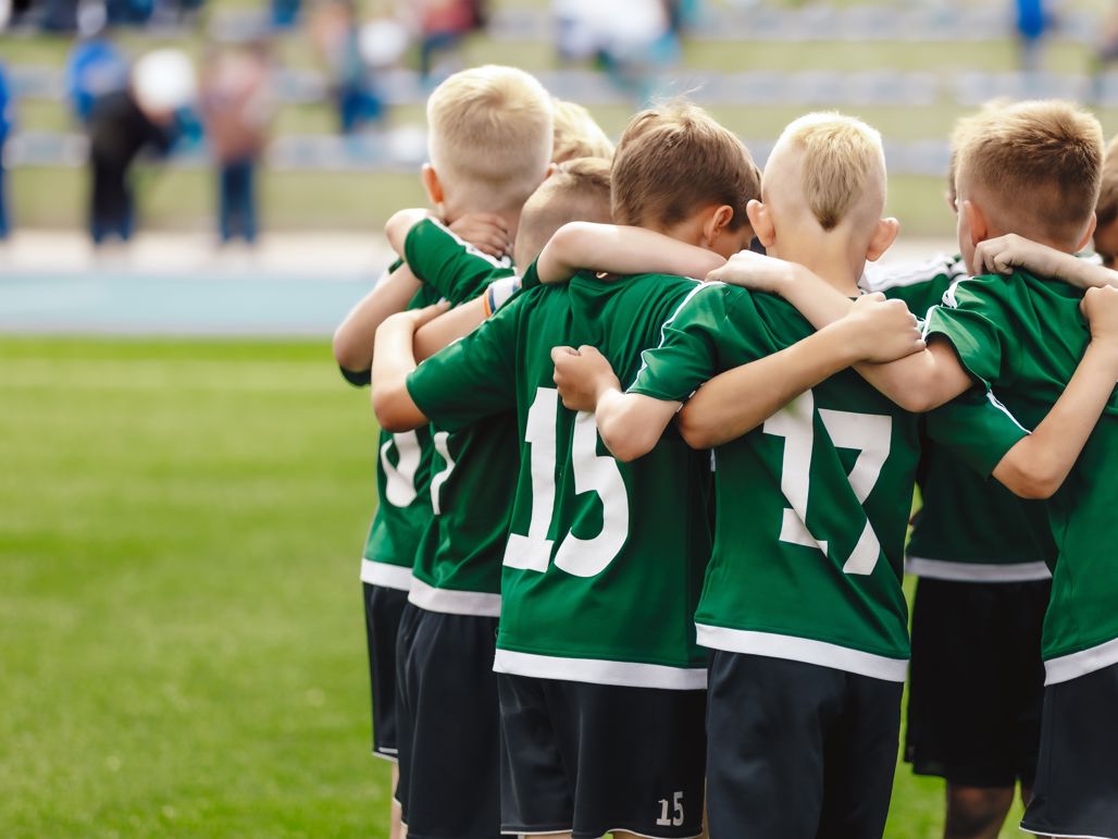 Pojkar som kramas på en fotbollsplan