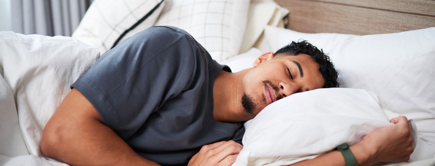 En man som sover i en säng