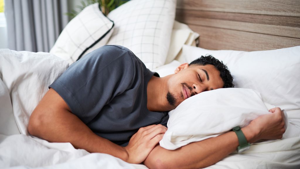 En man som sover i en säng