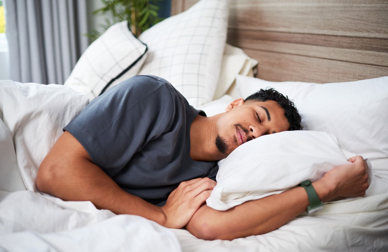 En man som sover i en säng