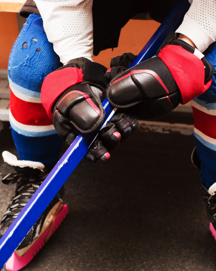 Omklädningsrum för hockeylag med utrustning och belysning.