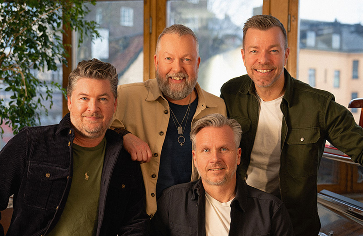 Pressbild på gruppen Arvingarna framför ett piano