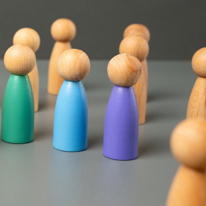 Spelpjäser i trä, i olika färger, på ett bord