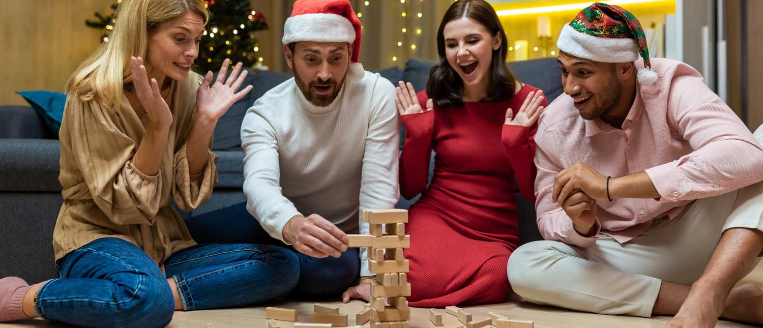 En grupp vänner spelar JENGA, iförda tomtemössor