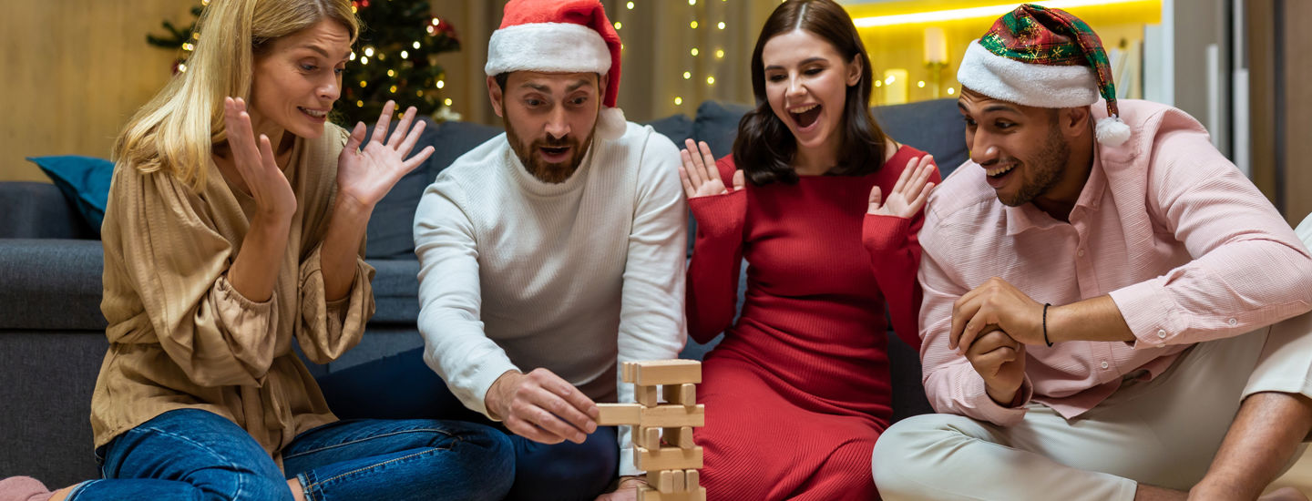 En grupp vänner spelar JENGA, iförda tomtemössor