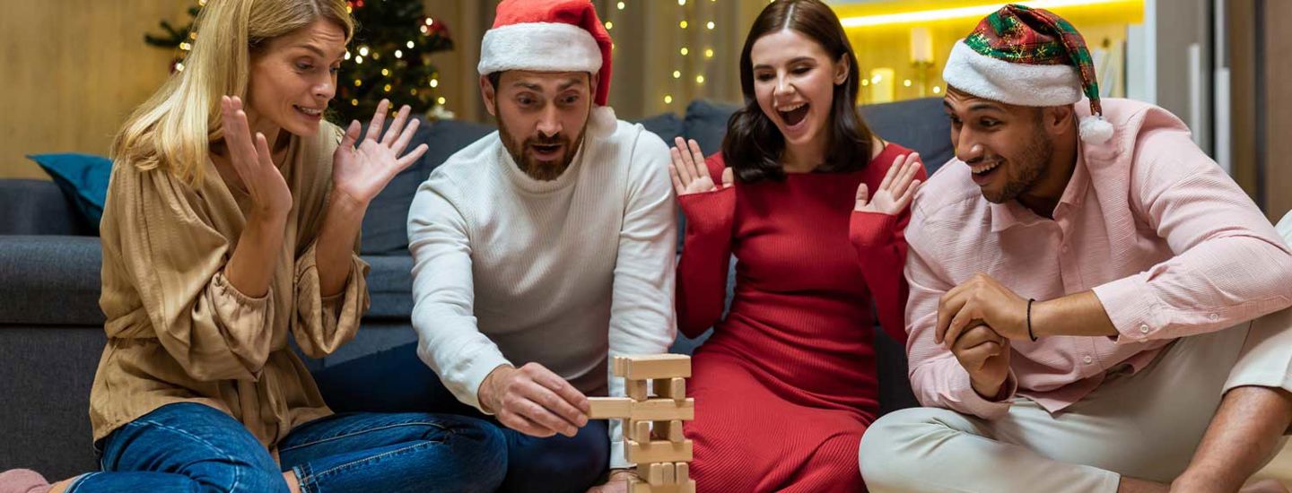 En grupp vänner spelar JENGA, iförda tomtemössor