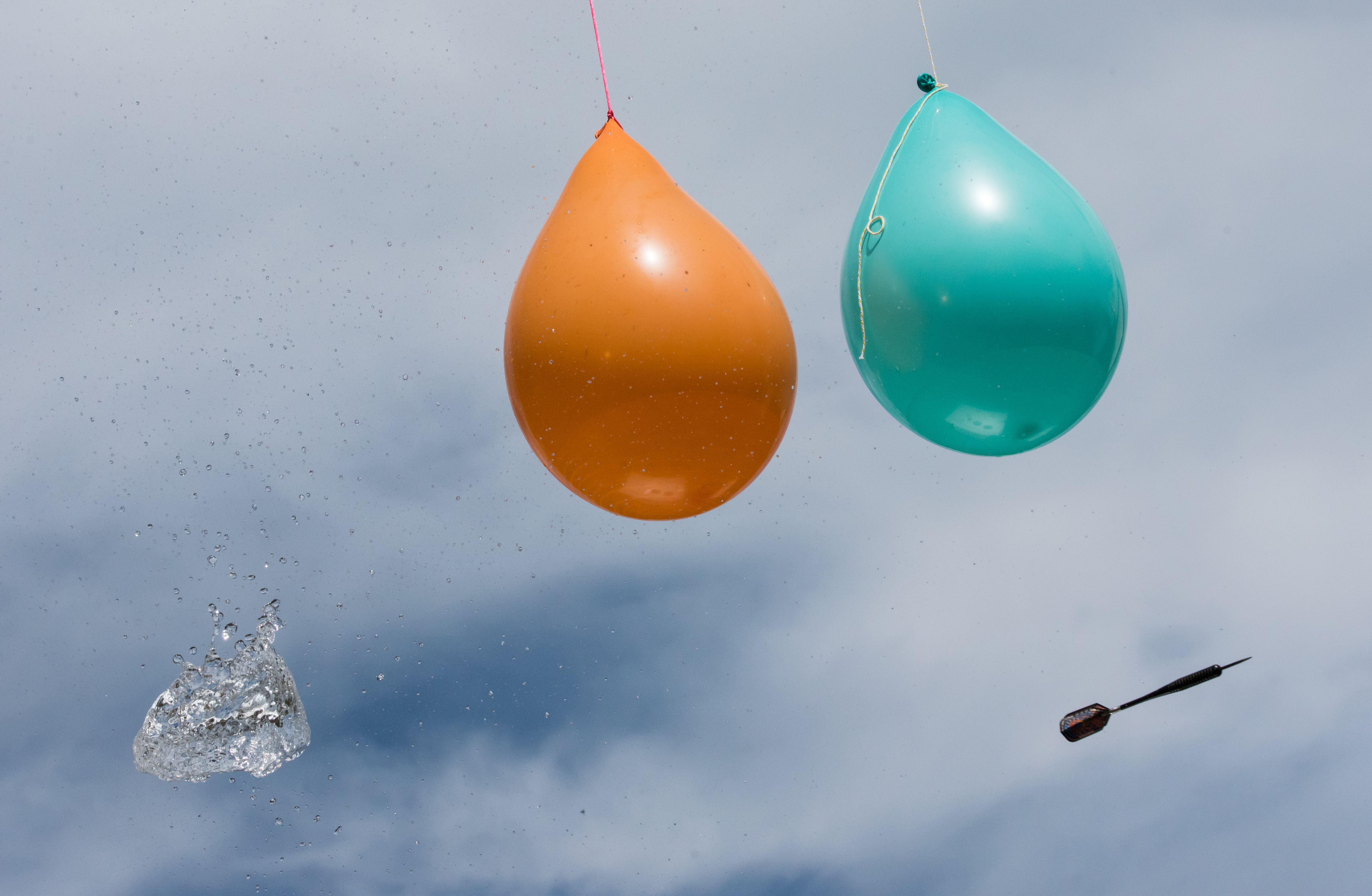 Vattenfyllda ballonger och en kastad dartpil