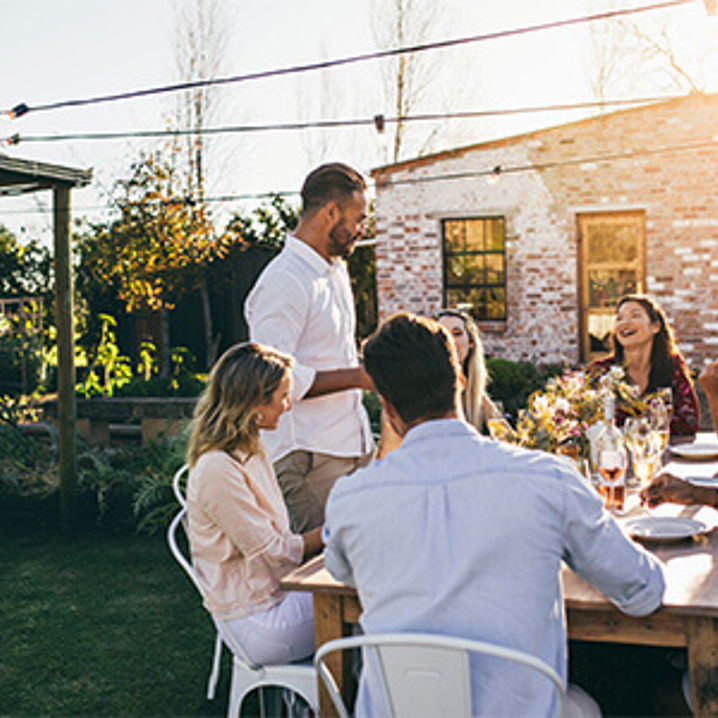 Grupp av människor firar midsommar tillsammans utomhus
