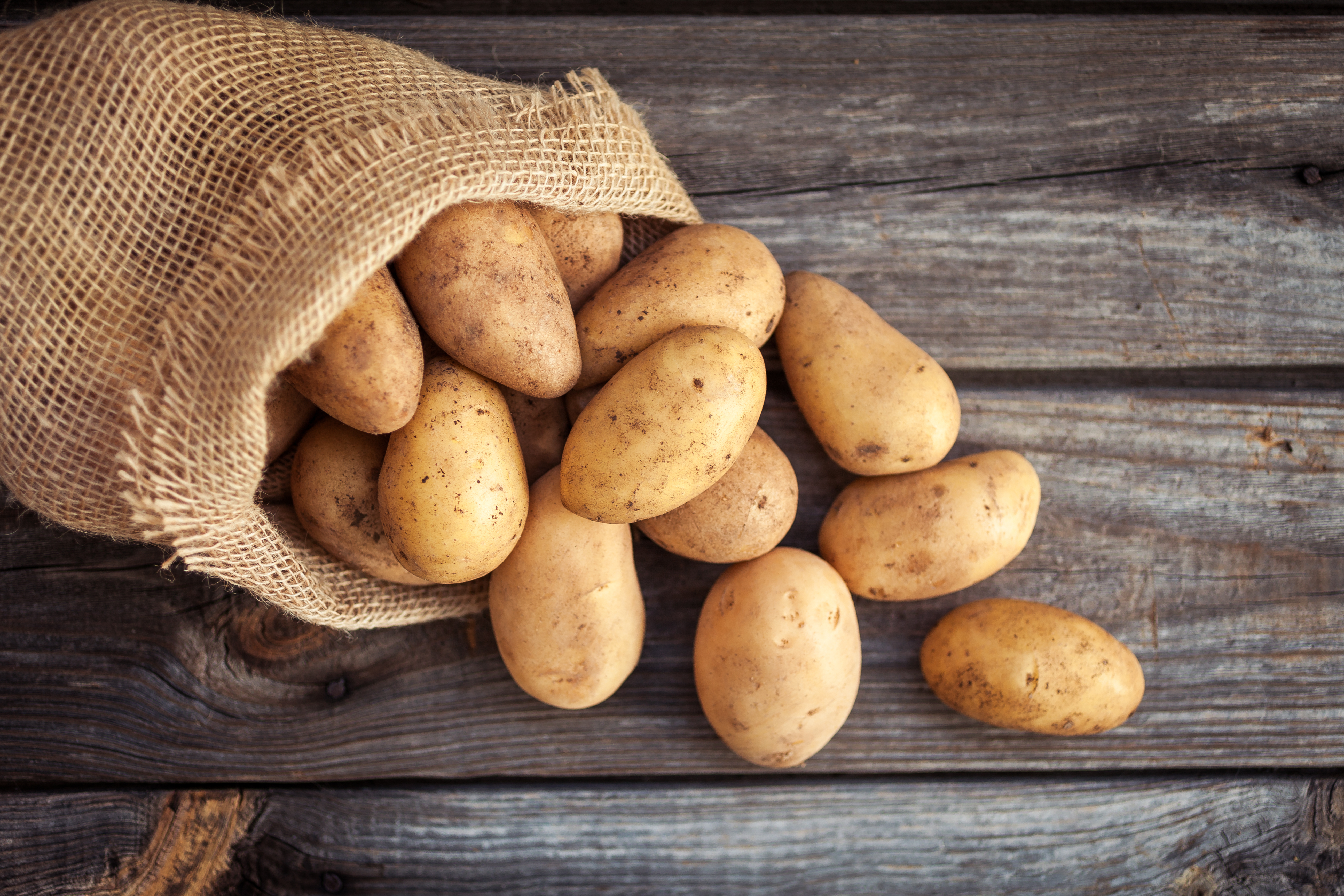 En säck potatis på ett träbord