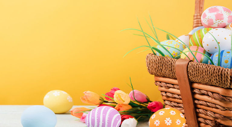 En gul bakgrund och en korg full av påskägg